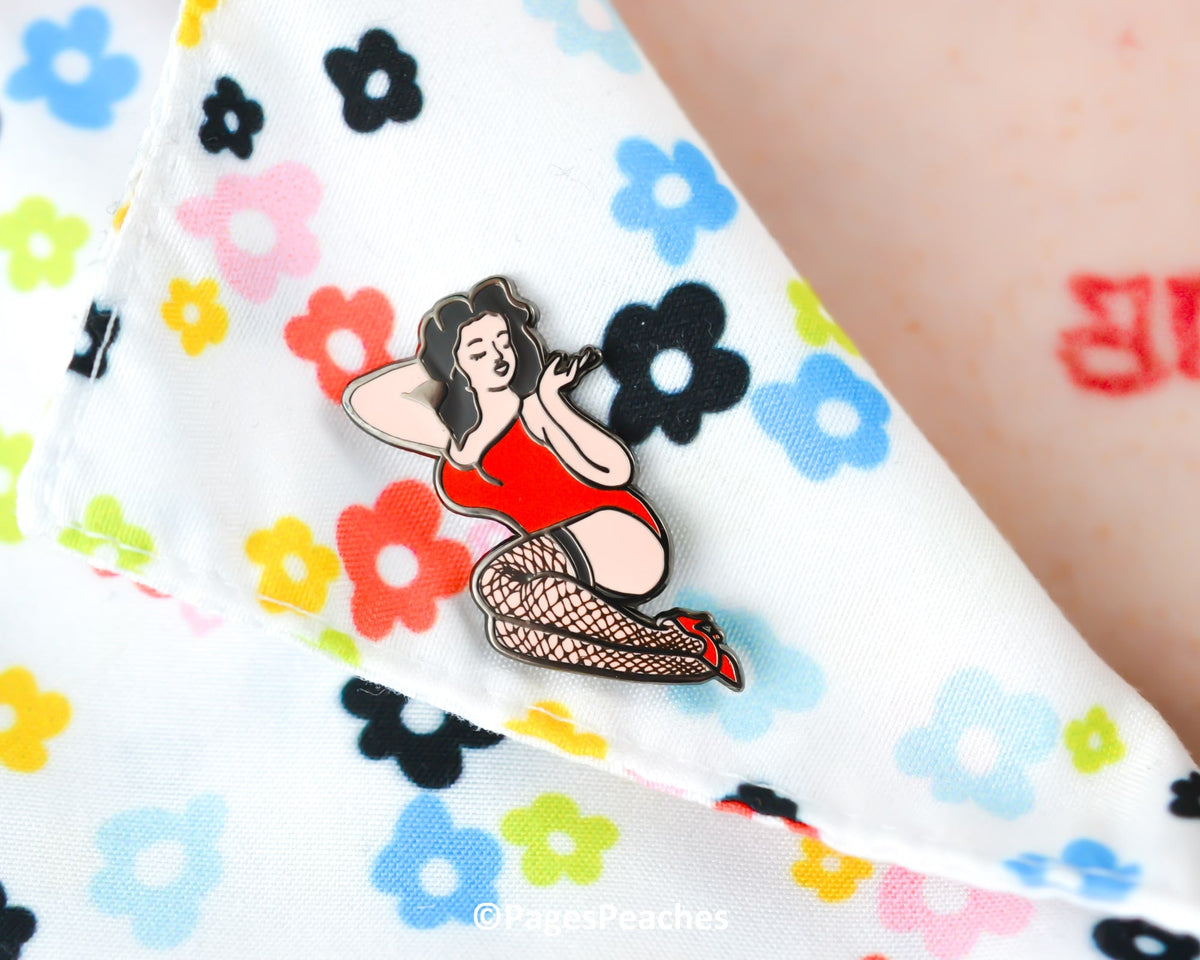 Hard enamel pin of a vintage-inspired pinup girl wearing red heels and fishnets, on a shirt collar