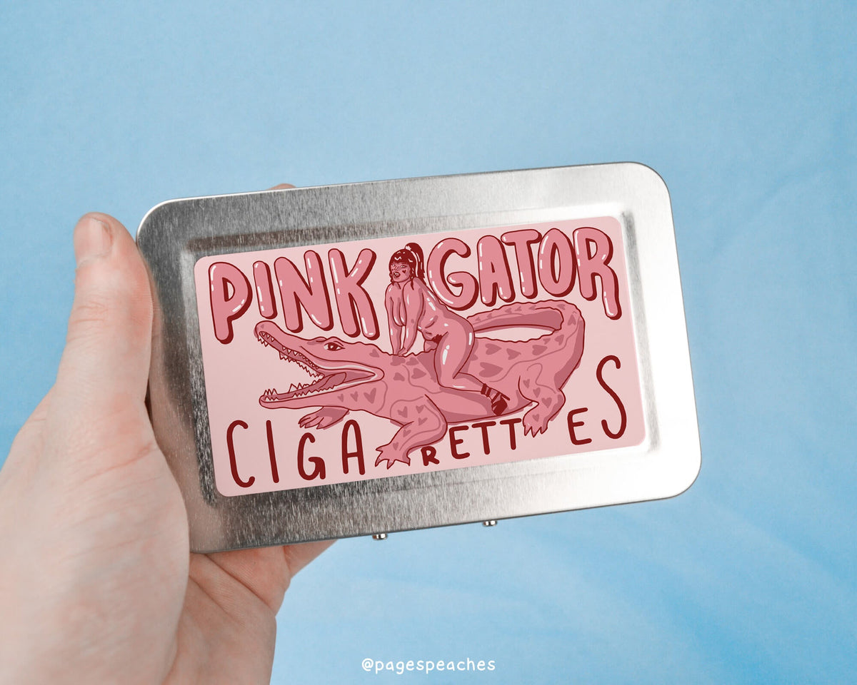 a person holding a tin with a pink gator cigarettes sticker on it