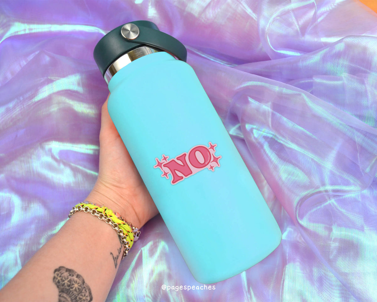 A person's hand holding a blue water bottle with a pink "NO" sticker on it, against a purple fabric background.
