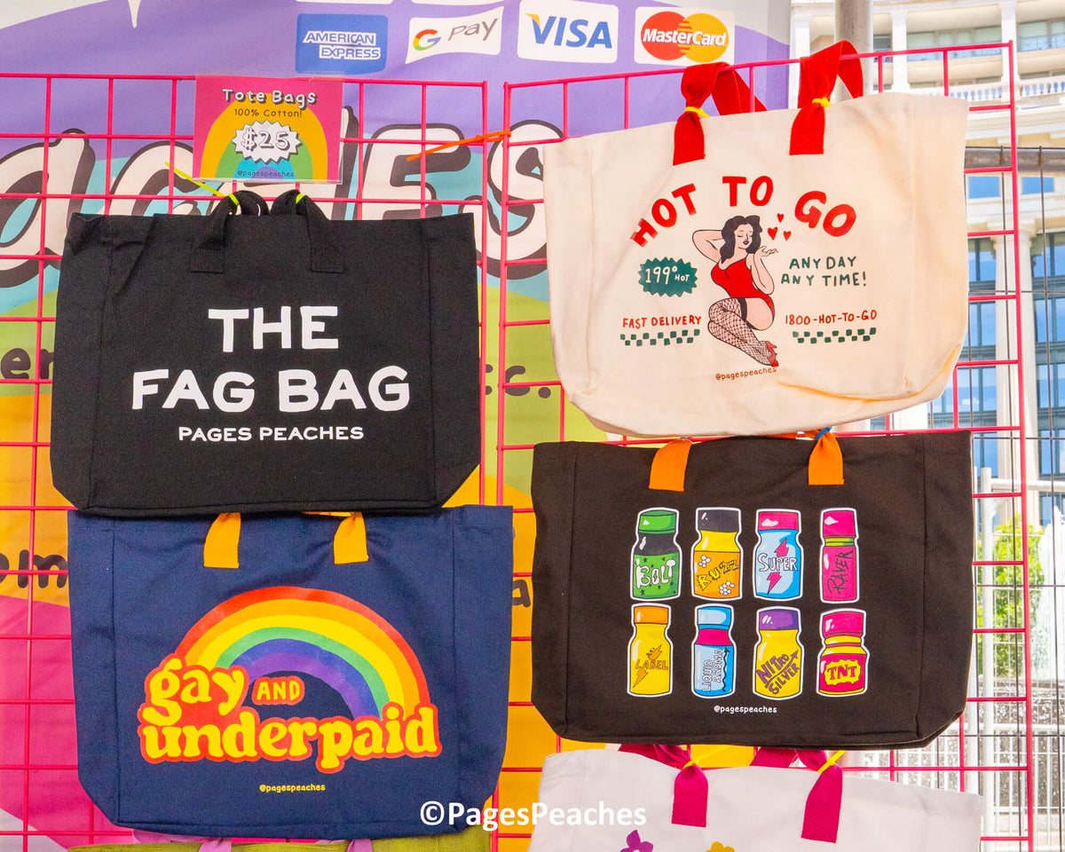 a collection of colorful tote bags with various designs and text, including a black bag with "THE FAG BAG" printed on it, a white bag with "HOT TO GO" and "ANY DAY ANY TIME" printed on it, and a blue bag with a rainbow graphic and the text "Gay and Underpaid" printed on it.