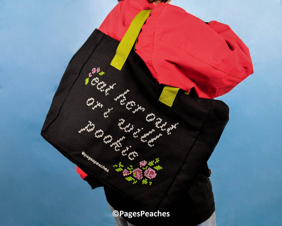 Black bag featuring floral cross-stitching and sassy slogan